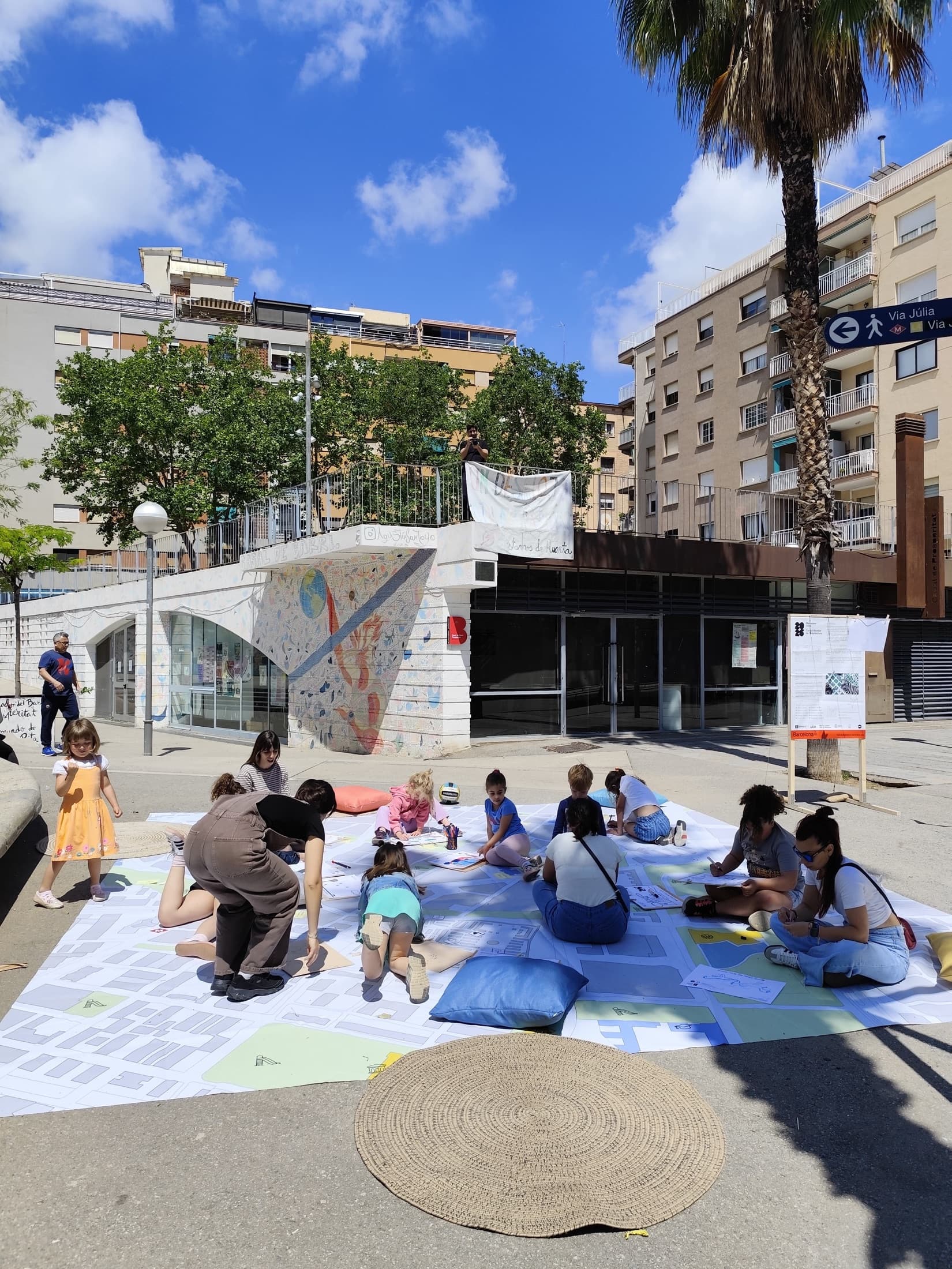 Niñas, niños y personas cuidadoras participando sobre un gran mapa